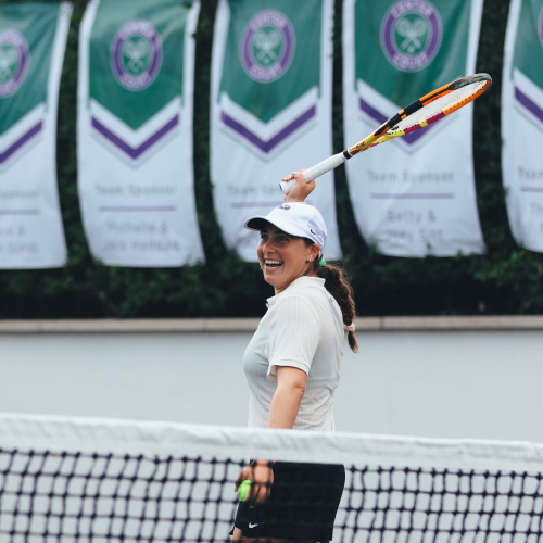 A player smiling at the net at Center Court 2023